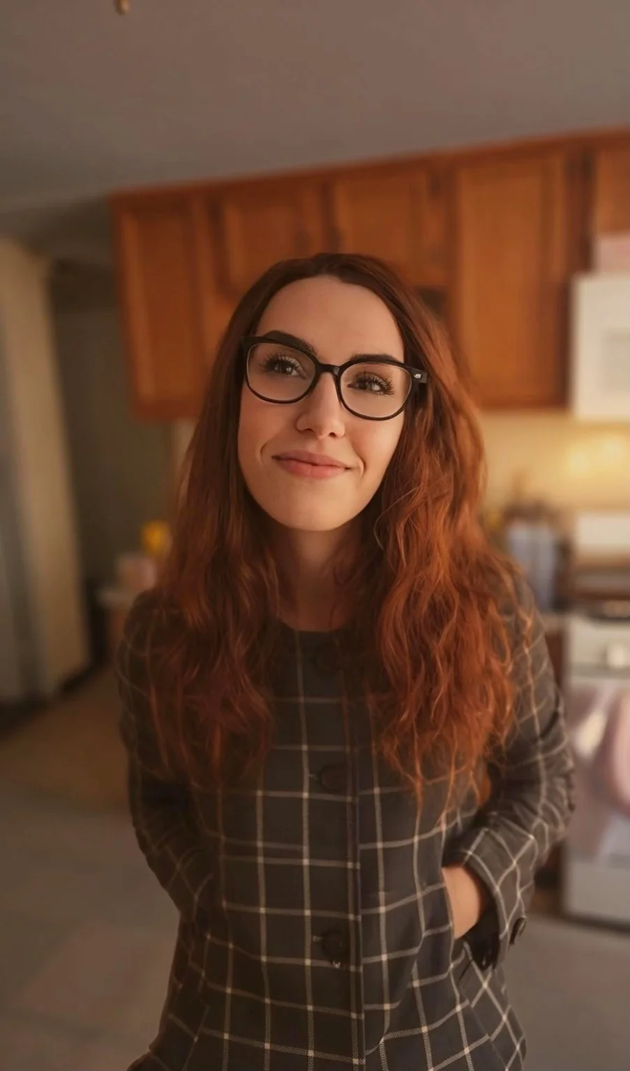 Erin Whitten wearing glasses and a plaid dress